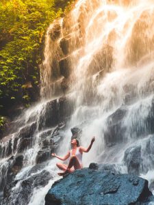 photo of a woman sitting in a waterfall