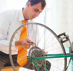 guy fixing a bicycle wheel