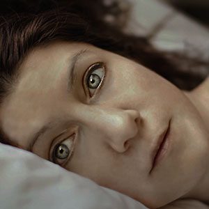 Woman wide eyed in bed suffering form insomnia due to menopause