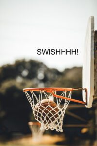 Picture of basketball swishing thorugh the hoop and netting.