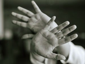 fearful hands in front of face