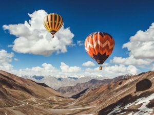 Hot air balloons flying over the mountains taking away and clearing your troubles.