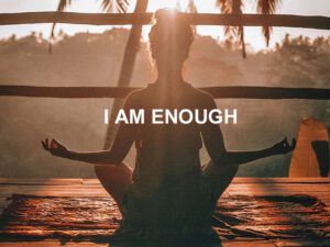 I am enough statement for self esteem written over woman doing yoga